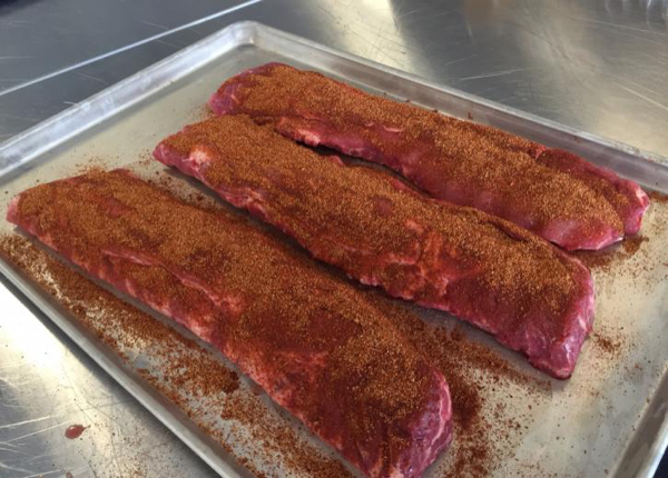 Rub the Texan Style rub into the ribs and place them in your rib rack